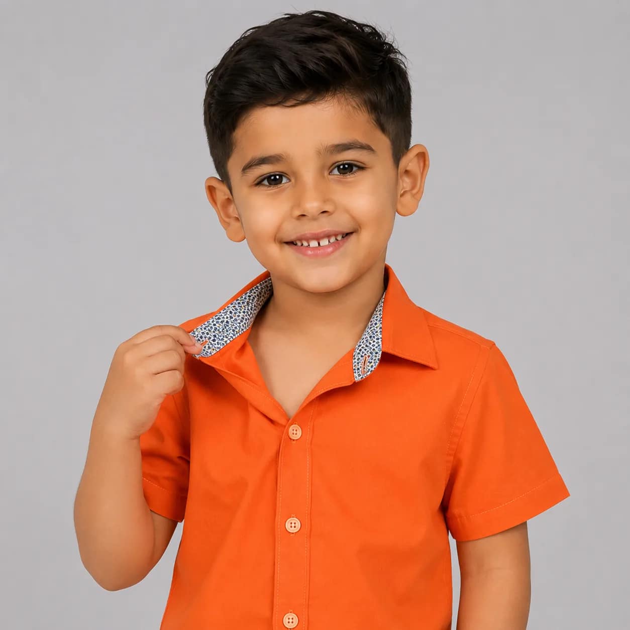Chemise garçon orange à manches longues avec col contrasté bleu, idéale pour un look élégant et coloré.