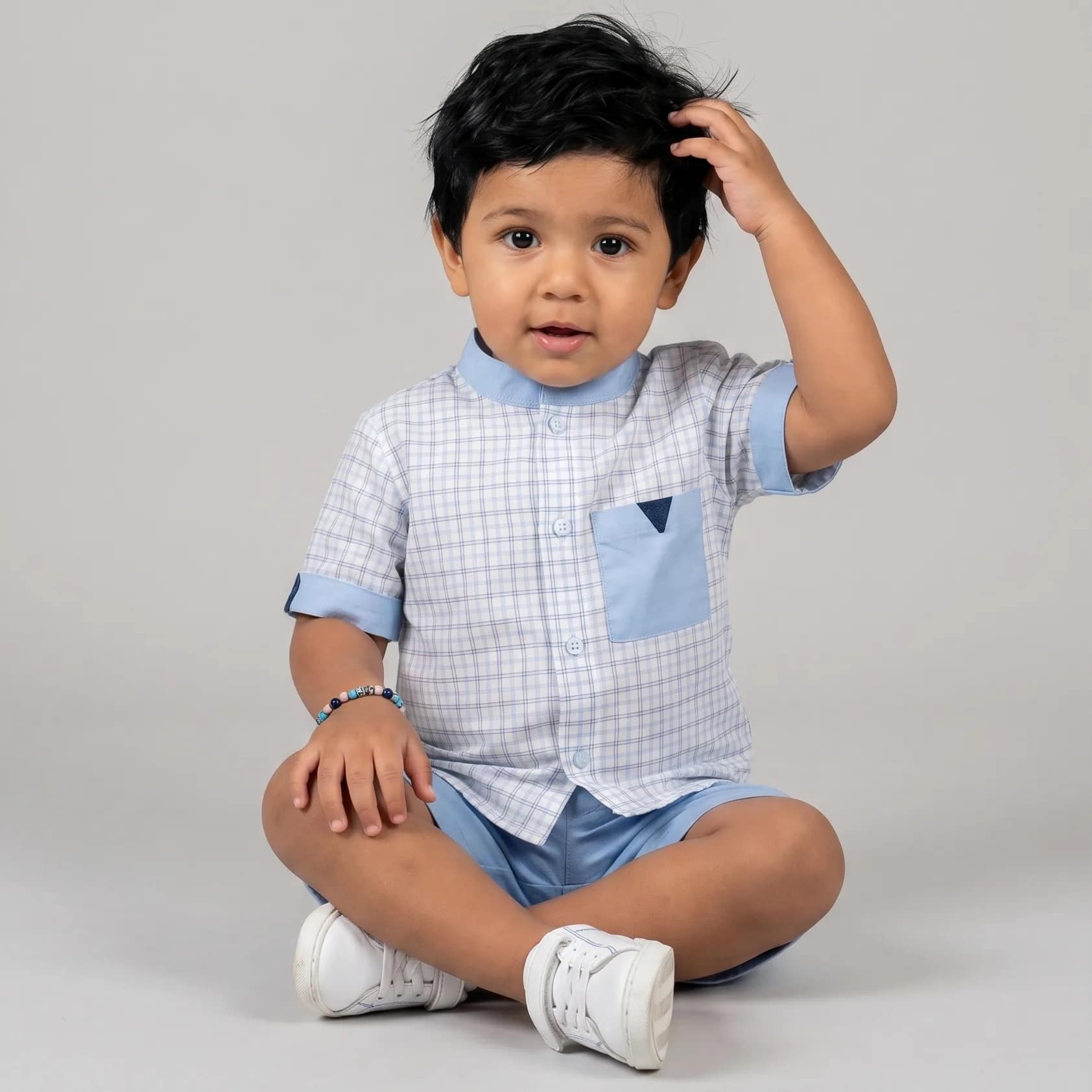 ensemble bleu ciel1 Ensemble chemise et short garçon élégant en coton bleu avec motifs, parfait pour occasions spéciales et sorties estivales.