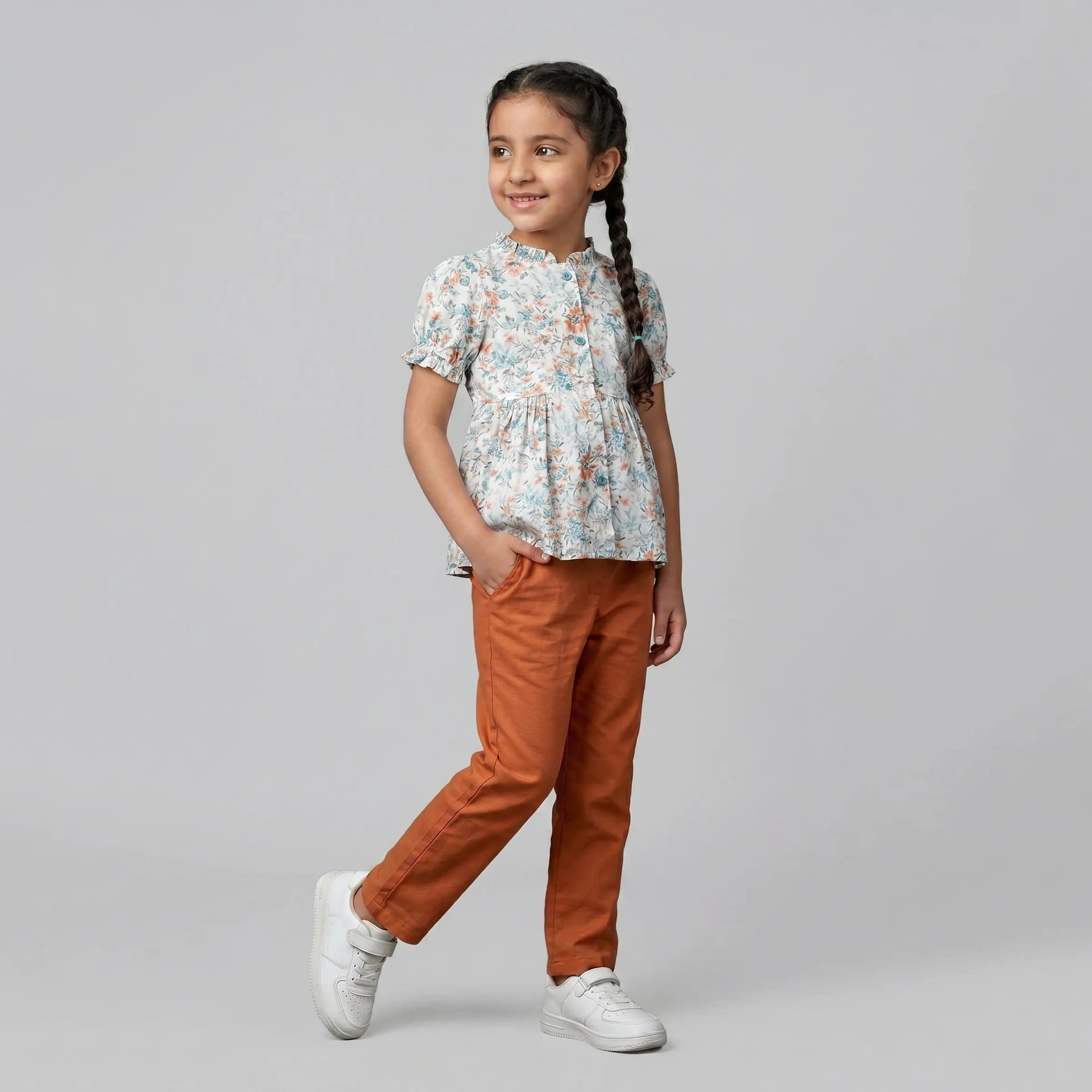 ensemble chemise fleuri pantalon orange1 Tenue décontractée fille avec tunique blanche et pantalon à motifs, idéale pour un look confortable et tendance.